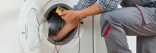 Dryer repair technician inspecting and repairing a clothes dryer in Austin, TX