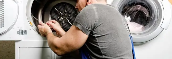 Dryer repair technician fixing a clothes dryer drum in Austin, TX