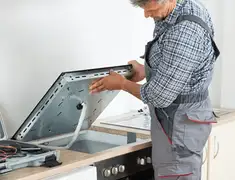 Appliance repair technician installing a built-in cooktop in Austin, TX