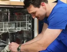 Dishwasher repair technician inspecting and servicing an open dishwasher in Austin, TX