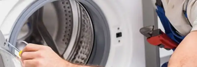 Appliance technician repairing a clothes dryer drum and internal parts in Austin, TX