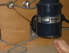 Garbage disposal repair technician tightening the mounting ring under a sink in Austin, TX