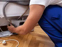 Appliance repair technician fixing refrigerator water line and connections in Austin, TX