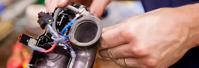 Vacuum repair technician reconnecting wiring and components in Austin, TX