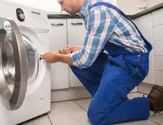 Washing machine repair technician servicing a front-load washer in Austin, TX