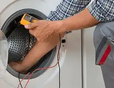 Washing machine repair technician testing a front-load washer with diagnostic tools in Austin, TX