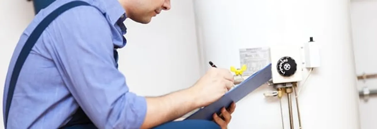 Water heater repair technician inspecting the unit and recording service notes in Austin, TX