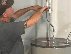 Water heater repair technician tightening supply line connections in Austin, TX
