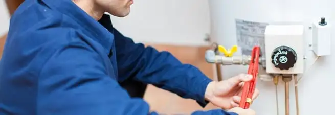 Water heater repair technician adjusting the temperature control and gas valve in Austin, TX